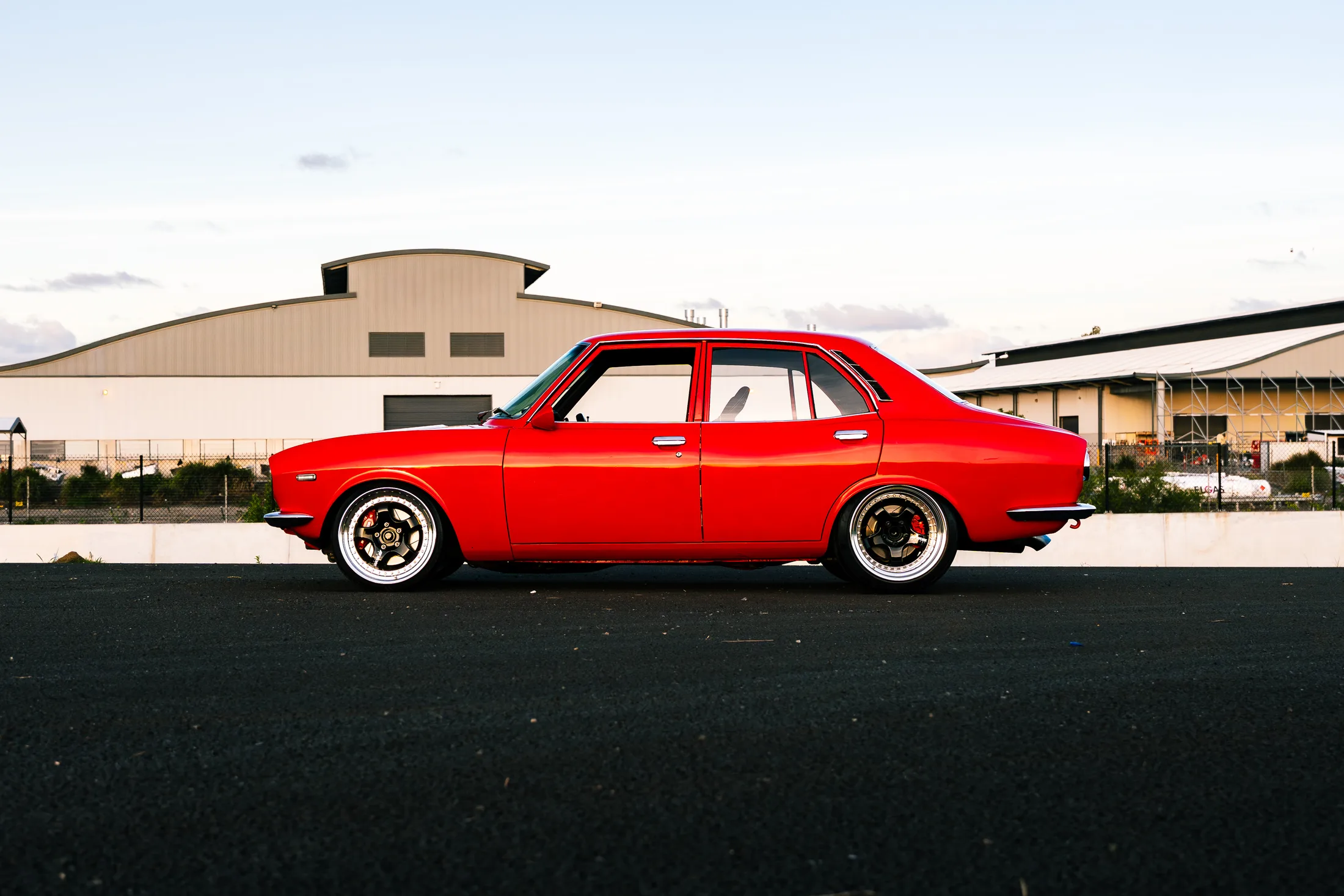 1971 Mazda Capella RX-2 in gloss red, low stance, front three-quarter.